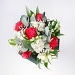 A lush hand-tied bouquet viewed from above, filled with crimson roses, vivid pink-red carnations, and cloudlike white chrysanthemums, arranged in a generous dome that feels like a handful of celebration. The roses sit at the heart of the design, their velvety, deep red petals spiralling open with classic romance, while the carnations around them add ruffled texture, almost feathery at the edges, in brighter cherry and raspberry tones. Between these bold blooms, clusters of small, daisy-like white chrysanthemums and tiny sprigs of gypsophila create a soft, snowy lightness, catching any stray beam of daylight as it falls across the arrangement. Cool eucalyptus leaves arc gracefully through the flowers, their muted silvery-green and distinctive round shapes contrasting with the glossy deep green tropical foliage beneath, which frames the bouquet like a subtle halo. The stems are bound tightly but thoughtfully, giving the design a compact, modern profile while still feeling airy and open, each flower clearly visible and given room to breathe. Imagined resting on a kitchen table in New Cross after a trip past Fordham Park, the bouquet seems to bring fresh air indoors: a mix of herbal eucalyptus scent, gentle rose perfume, and the clean green aroma of just-cut foliage. The overall mood is upbeat and affectionate, perfect for birthdays, homecomings, or a spontaneous gift to brighten a flat near New Cross Gate station. It feels like holding spring in your hands, crafted with attentive care by a local florist who understands how to balance colour, texture, and movement so that the bouquet speaks of joy without ever feeling formal or stiff.